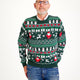 En mand poserer i en grøn julesweater med nisser, rensdyr og mønster på.