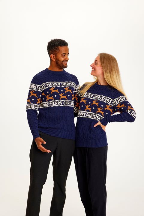 En mand og en dame iført en blå julesweater med rensdyr på.